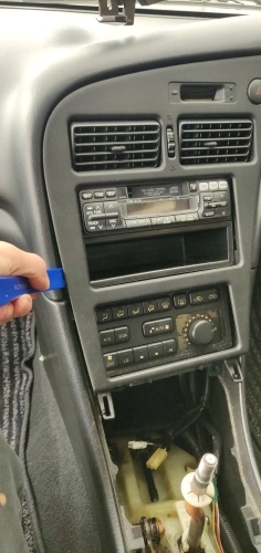 Prying off the head unit trim with a trim tool