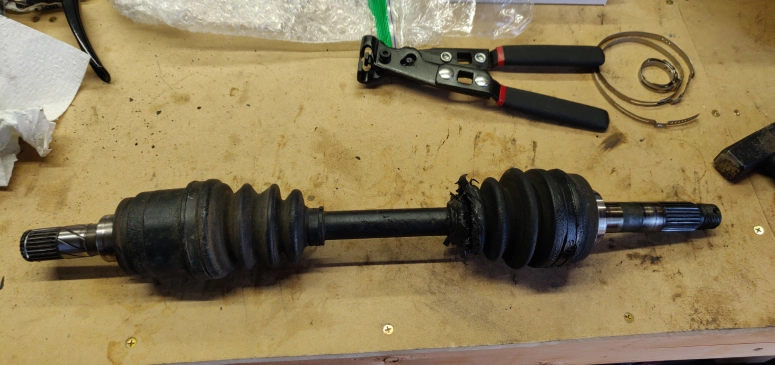 CV axle on bench with torn boots