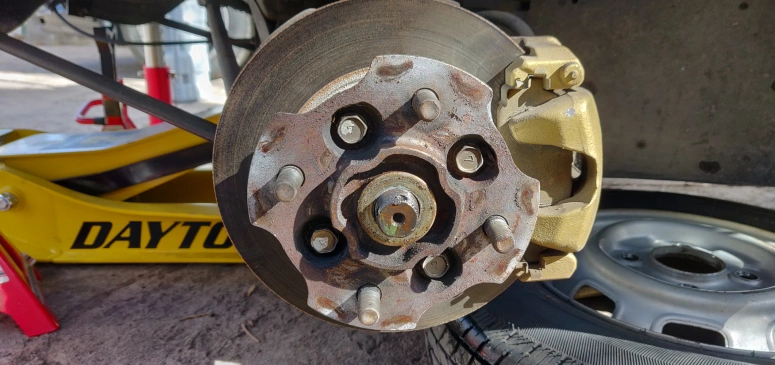 Wheel and axle nut removed exposing 4 hub bolts